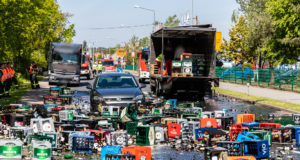 Ladung von Getränkelaster kippt auf PKW