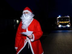 Weihnachtsmann verteilt kleine Geschenke mit der Feuerwehr