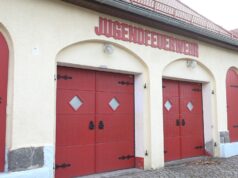 Feuer am Feuerwehrhaus Barnten: Polizei ermittelt wegen versuchter Brandstiftung Fassade eines Feuerwehrhauses mit roten Holztoren.